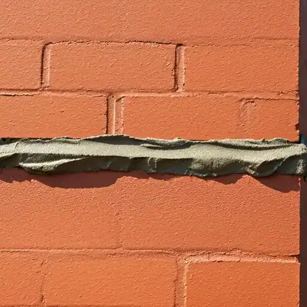 Close-up of expert masonry work showing professional tuckpointing on a classic brick chimney