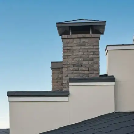 Exterior shot of a modern chimney being inspected by a professional