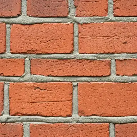 Detailed, close-up photograph of a professional tuckpointing job on a historic red brick wall in Northfield, Minnesota