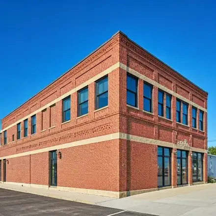 Wide architectural shot of a brick commercial building in downtown Hugo featuring decorative masonry work