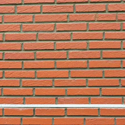 Shot of professional tuckpointing work on a traditional red brick chimney in a suburban Minnesota setting in Apple Valley, MN